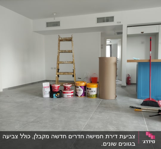 סולמות, דליי צבע וכלי עבודה בחדר ריק